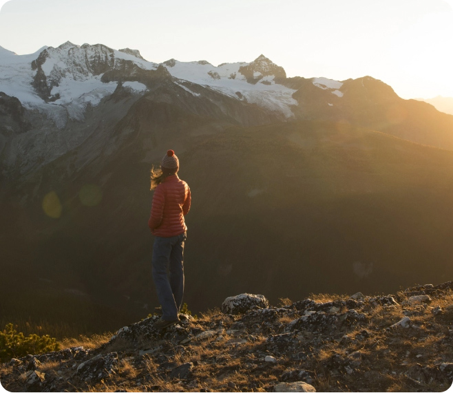 Woman on mountain ridge at sunset